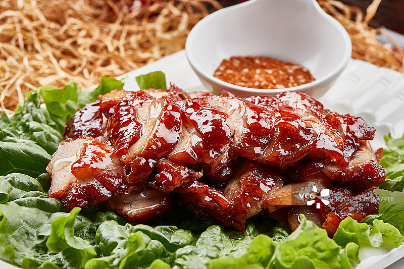 白色瓷盘装的蜜汁叉烧鸡腿肉图片素材