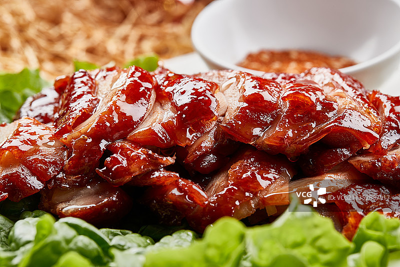 白色瓷盘装的蜜汁叉烧鸡腿肉图片素材