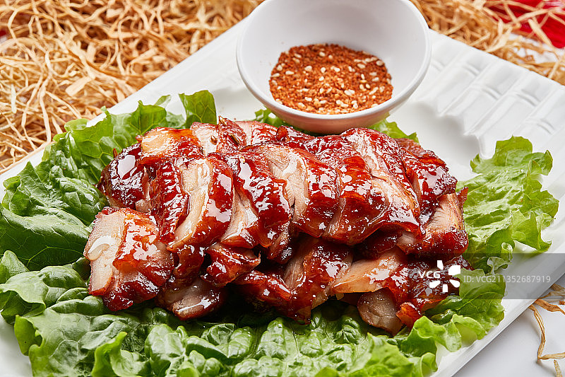 白色瓷盘装的蜜汁叉烧鸡腿肉图片素材