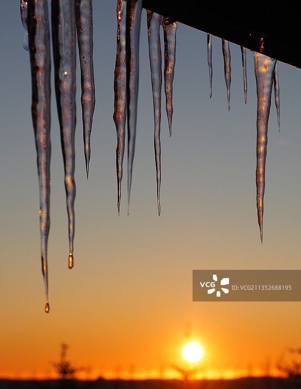 日落时分天空下的冰柱特写图片素材