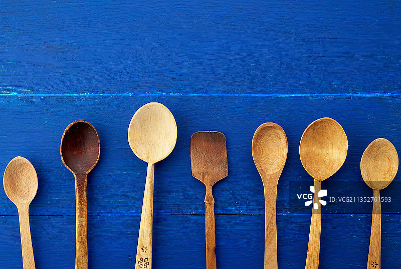 蓝色背景上的木勺俯拍图片素材