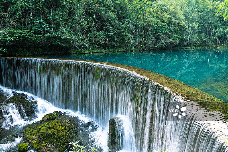 荔波小七孔幽蓝深邃的卧龙潭，人造瀑布像月牙梳，水流如发丝顺滑图片素材