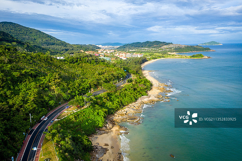 海南万宁沿海旅游公路，海浪拍打着礁石，公路蜿蜒穿行在海岸线上图片素材