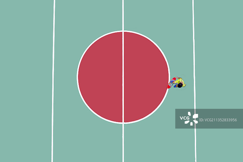 色彩鲜明的球场上一个身穿黄色衣服的小孩正在玩红色滑板图片素材