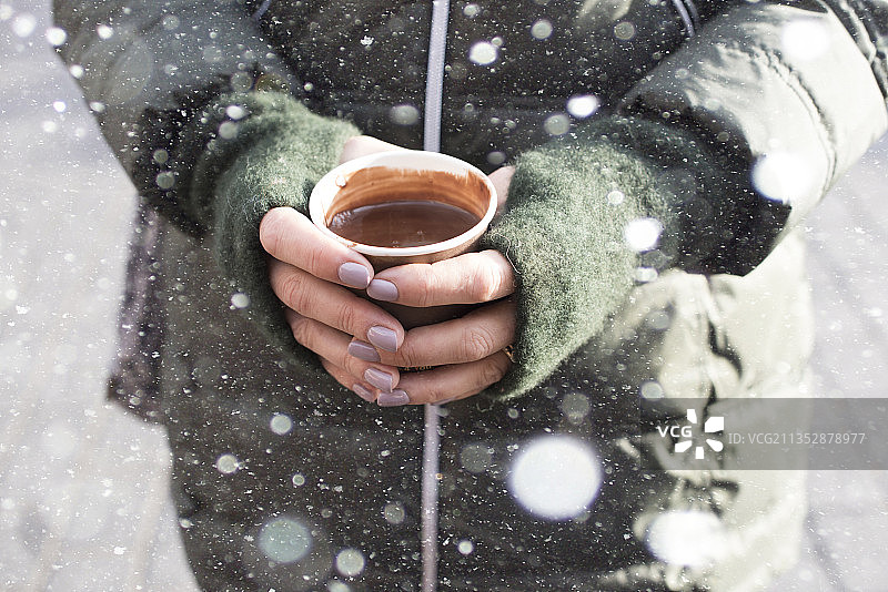 冬天，女人拿着咖啡杯的身体中部照片图片素材