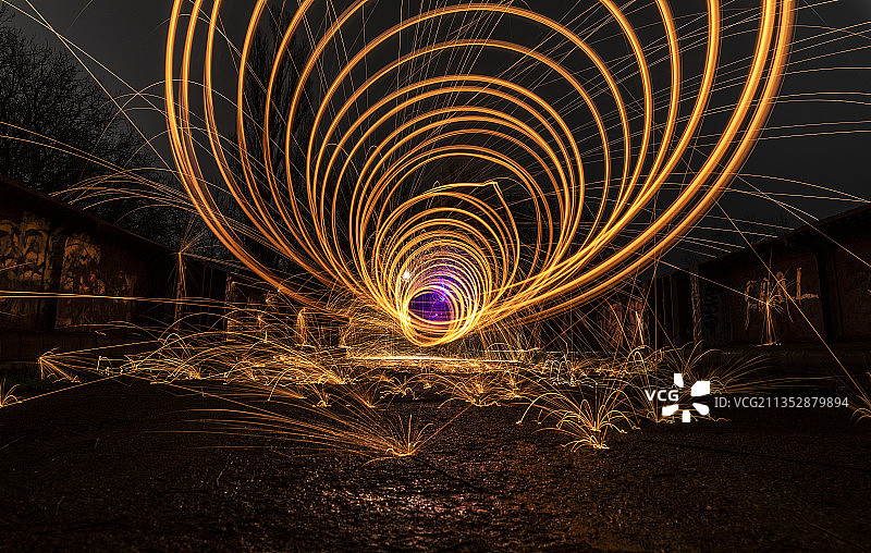 男人在夜间甩动钢丝棉，贝德福德，英国图片素材