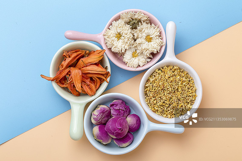 俯拍夏天清新蓝色橙色背景的多种花茶特写图片素材