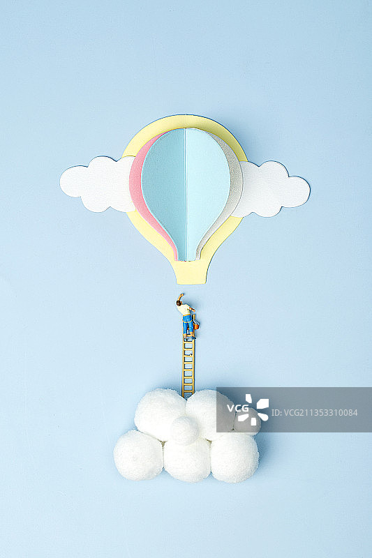 云朵上攀爬梯子想去热气球上的微缩小人图片素材