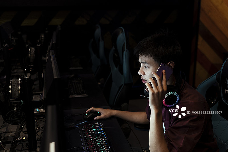 亚洲玩家打电话询问朋友是否加入游戏大厅。图片素材