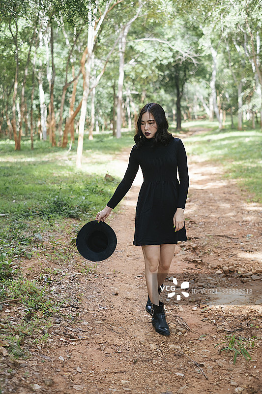 黑巫师女孩在森林中转身成为她的走秀台。图片素材