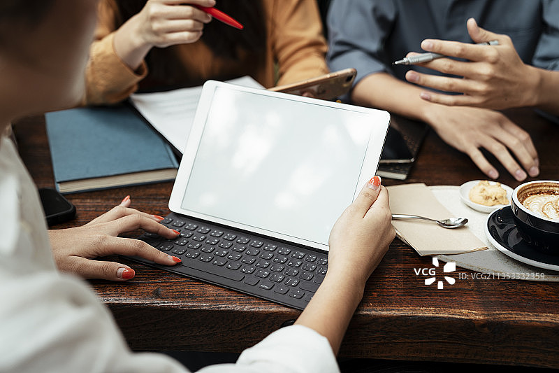 三个年轻的商人在会议上使用笔记本电脑。在平板电脑上复制空间。技术涉及到每一项业务。图片素材