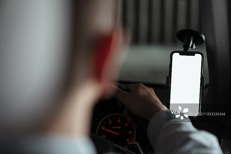 引航器对着汽车前玻璃的后肩镜头引导司机。图片素材