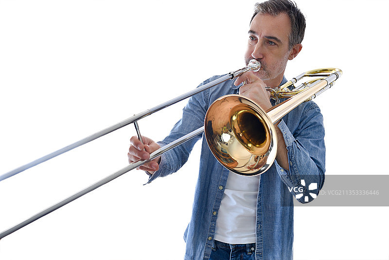 在白色背景下吹小号的男人图片素材