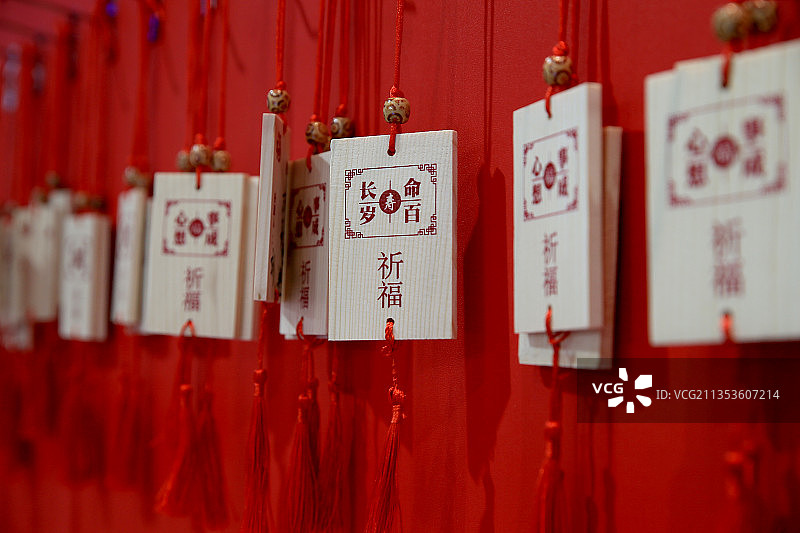 红色背景下悬挂的祈福的木牌图片素材