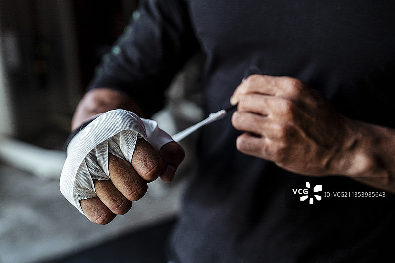 运动员亚洲泰国体育男子滚动拳击磁带周围的手。拳击运动员准备比赛。泰拳。图片素材