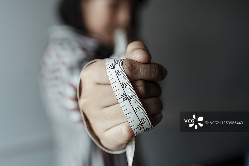 复制空间-年轻的亚洲设计师女人手持卷尺在手。大特写镜头。图片素材
