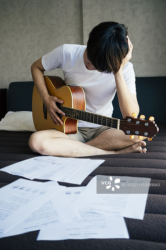 年轻的泰国吉他手的问题如何演奏原声吉他。吉他太难弹了。图片素材