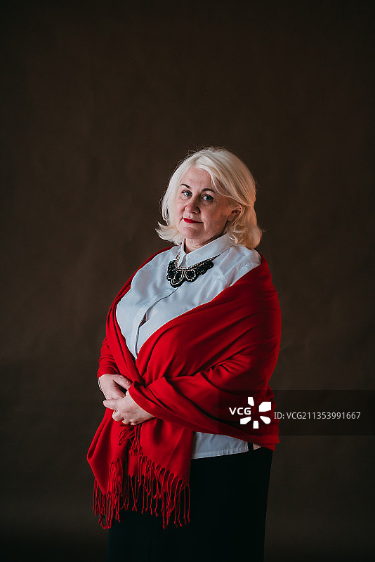 站在黑色背景前的中年妇女的肖像照图片素材