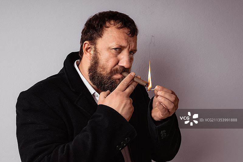 男人站在灰色背景前抽烟图片素材