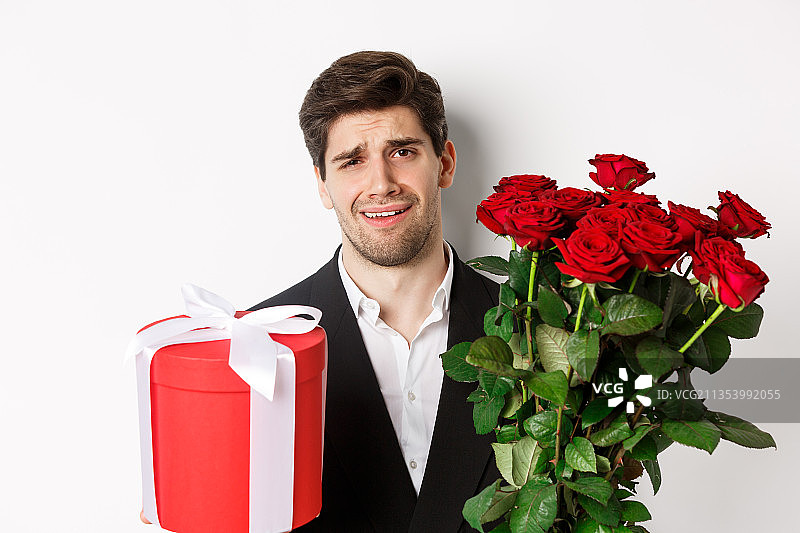 微笑男人在白色背景前拿着花束的肖像图片素材