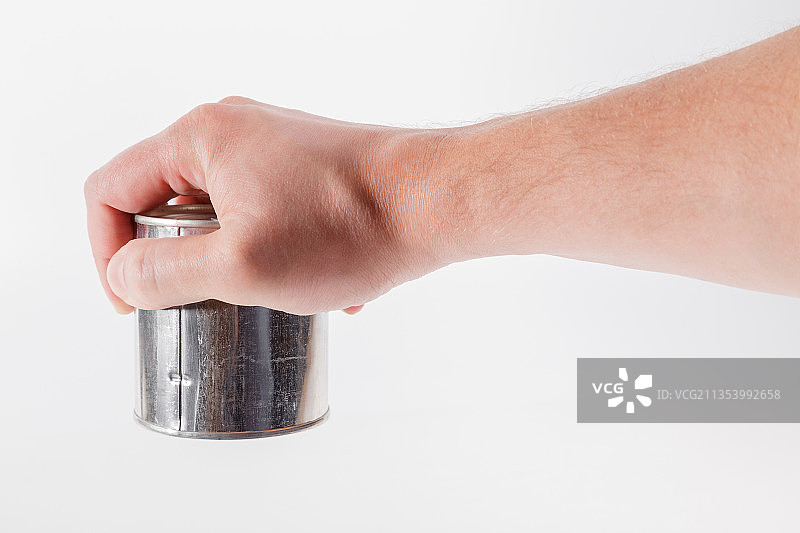 在白色背景下手持瓶子的局部照图片素材