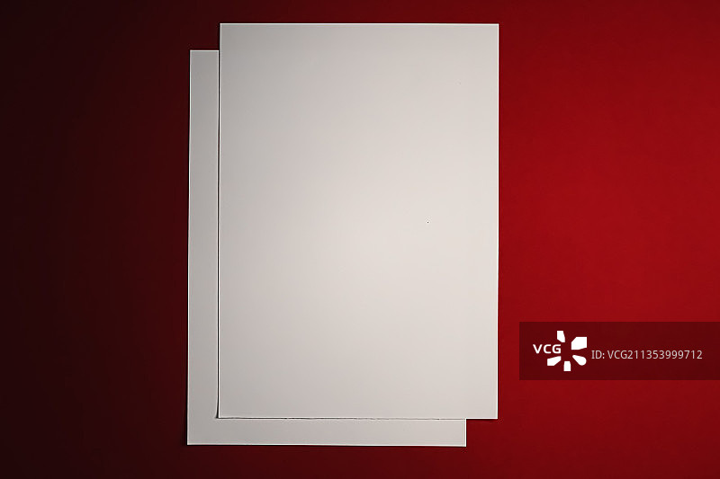 红色背景上的空白纸张特写图片素材