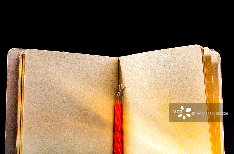 黑色背景上打开的书本和铅笔的俯视图图片素材