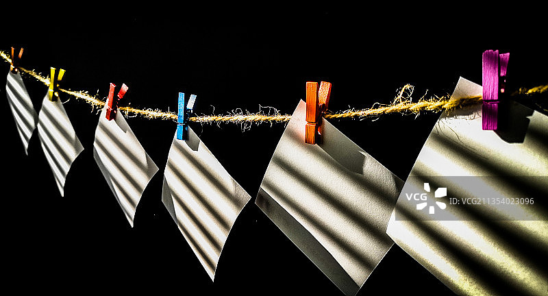 黑色背景下晾衣绳上的丝带特写图片素材