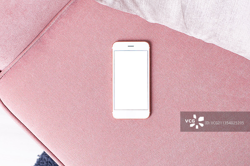 粉色织物上智能手机的俯视照片图片素材