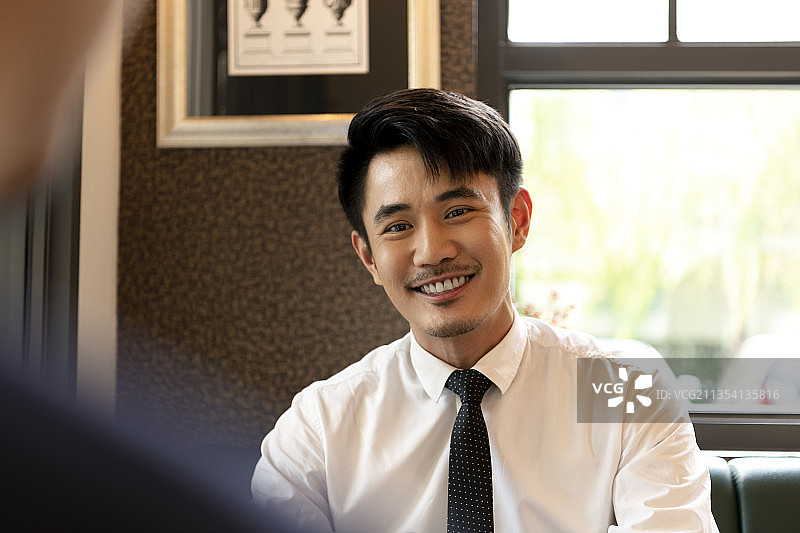 穿着白衬衫的亚洲商人用手提电脑面试应聘者。图片素材