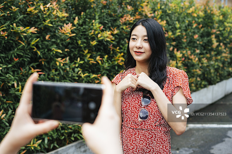 美丽的亚洲泰国女人视频与朋友拿着相机。美食博客。用智能手机的摄像头拍摄视频和照片。在电话上复印空间。图片素材