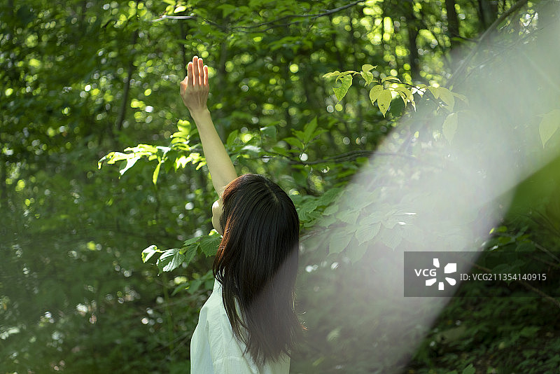 女人伸手向着光图片素材