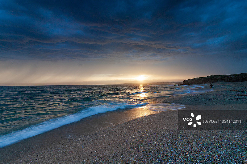 日落时，天空映衬下的海滩风景图片素材
