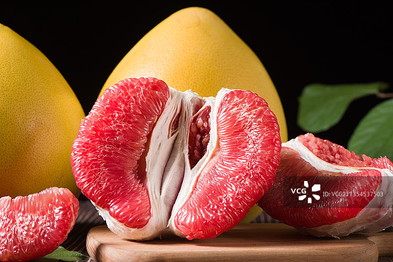 深色木底上的红心柚子果肉图片素材