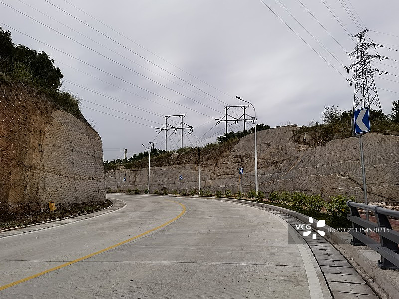 一条两边都是岩石的水泥公路图片素材