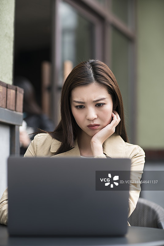 年轻女子在咖啡厅使用笔记本电脑图片素材