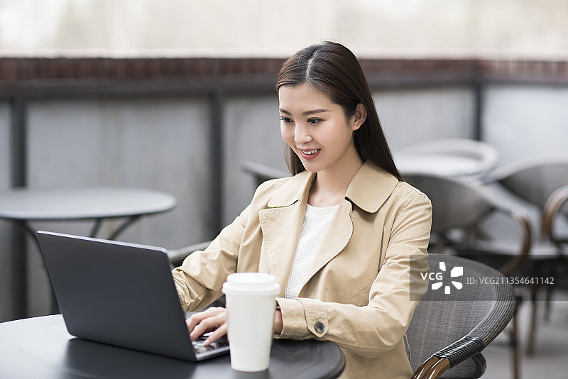 年轻女子在咖啡厅使用笔记本电脑图片素材