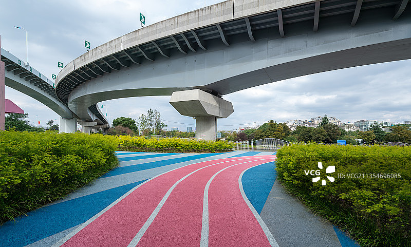 高速公路立交桥下的市民休闲健身彩色步道图片素材