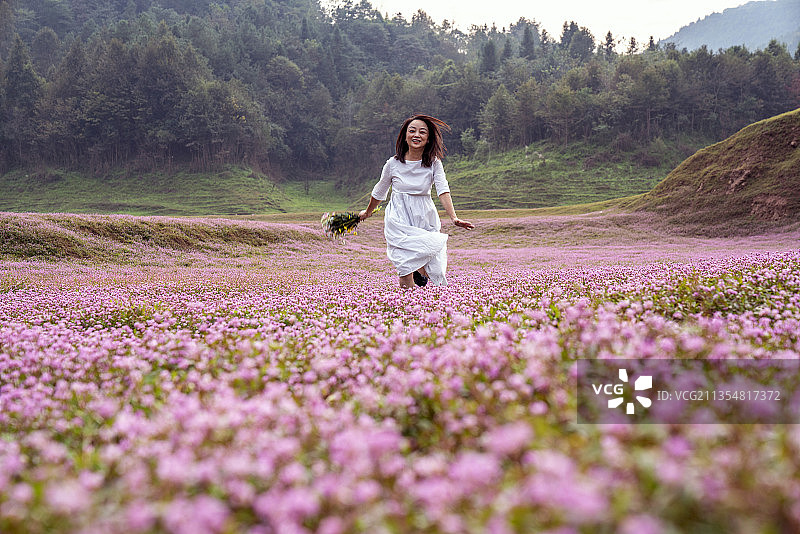 湖北：一位女性深秋在鲜花开放的草地上享受大自然的美好图片素材