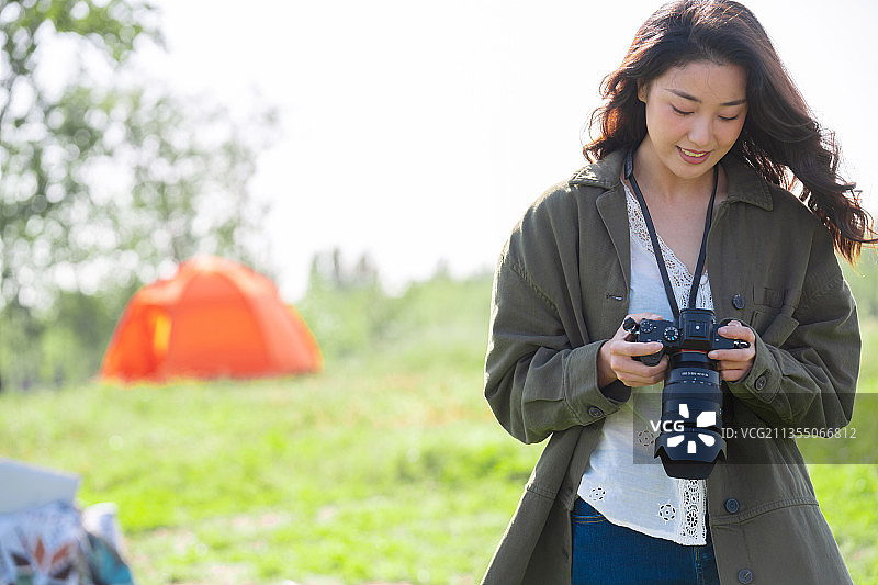 青年女性在户外露营地拿着相机图片素材