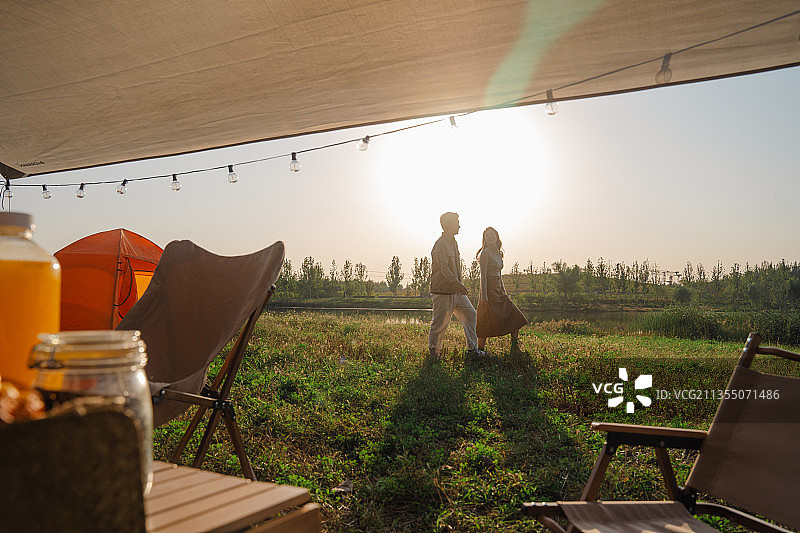 青年情侣在露营地湖边散步图片素材