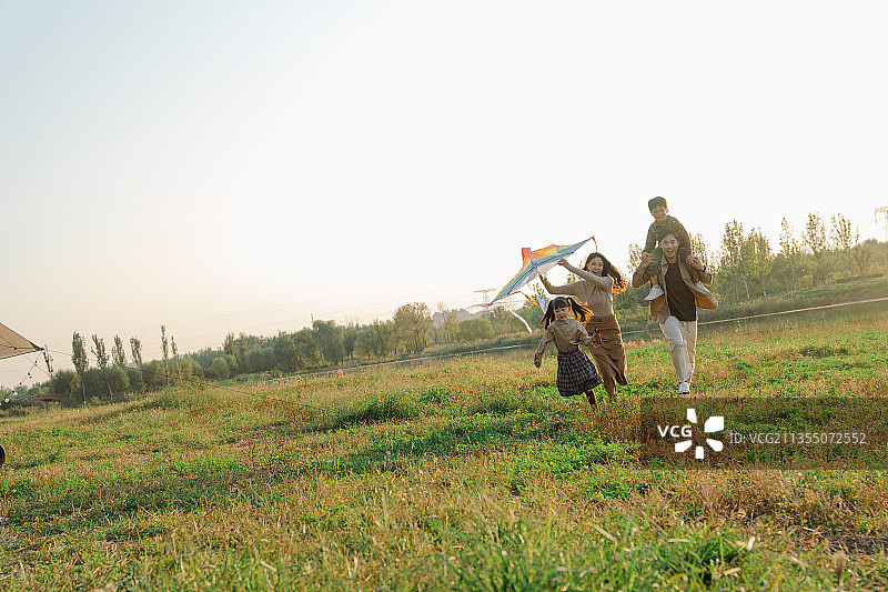 一家四口在公园放风筝图片素材
