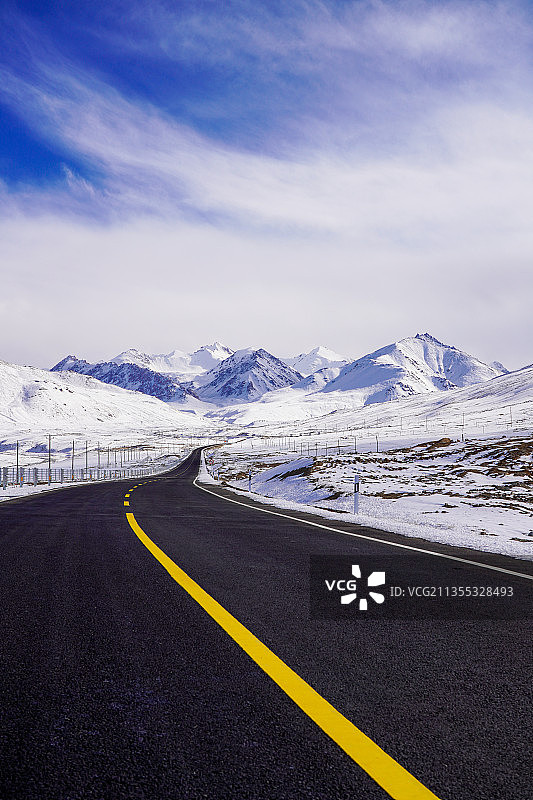 垂直画幅的新疆帕米尔高原，喀喇昆仑公路，前进的道路通向雪山图片素材