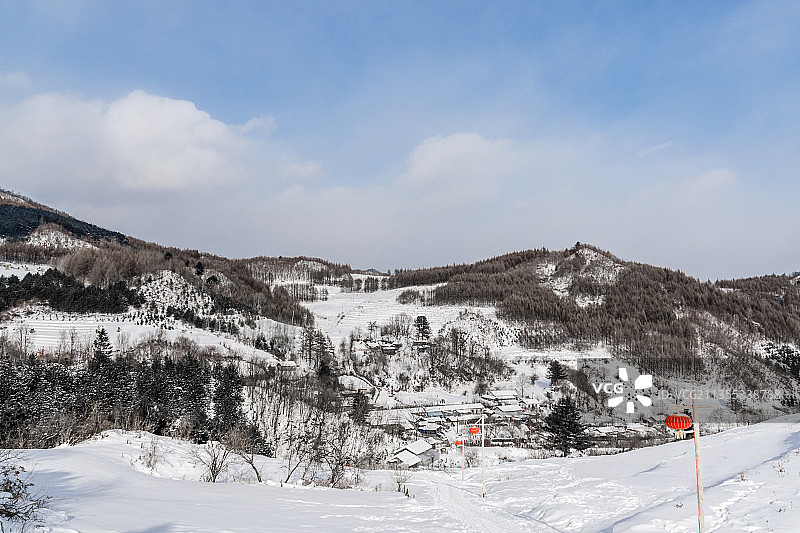 日出下的中国吉林延边大兴安岭的雪地树林和村庄图片素材