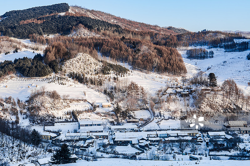 日出下的中国吉林延边大兴安岭的雪地树林和村庄图片素材