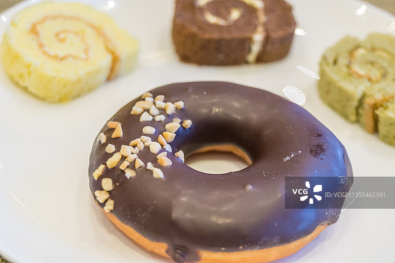 一盘甜甜圈和蛋糕卷特写图片素材