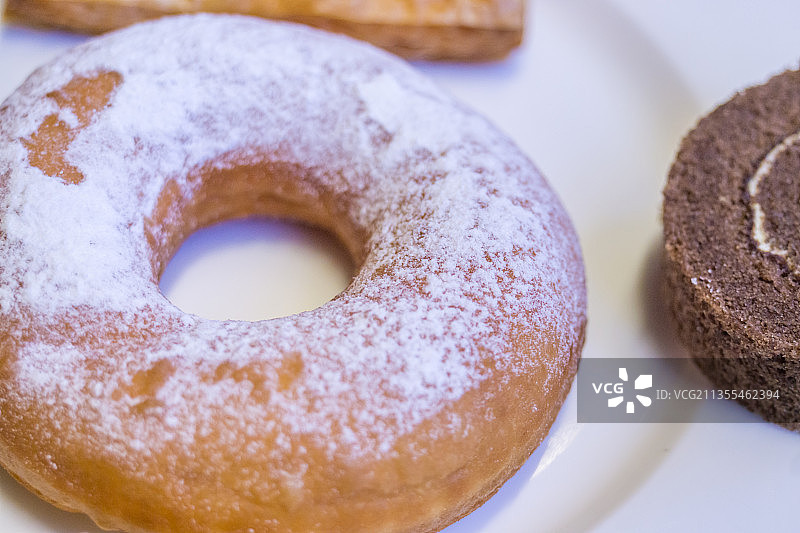 一盘甜甜圈和蛋糕卷特写图片素材