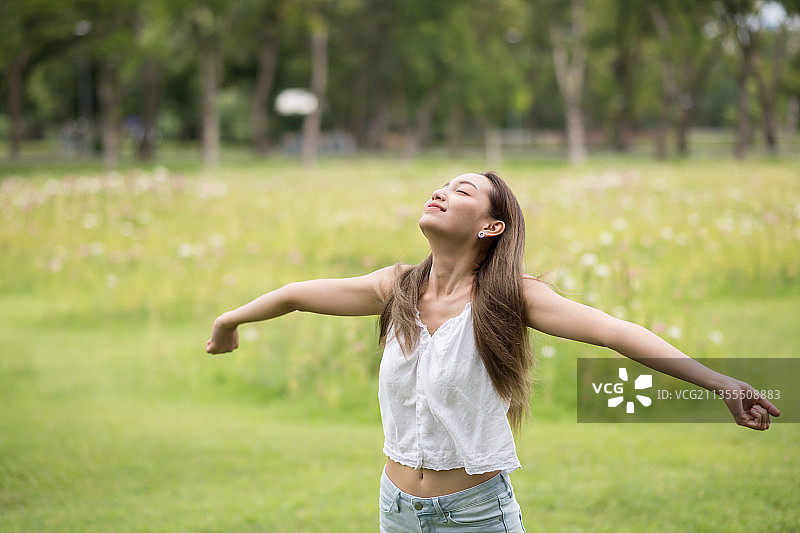 站在田野上的年轻女子（泰国曼谷）图片素材