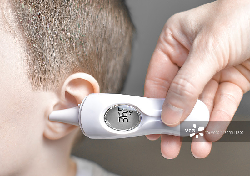 使用耳温计测量温度的手势图片素材