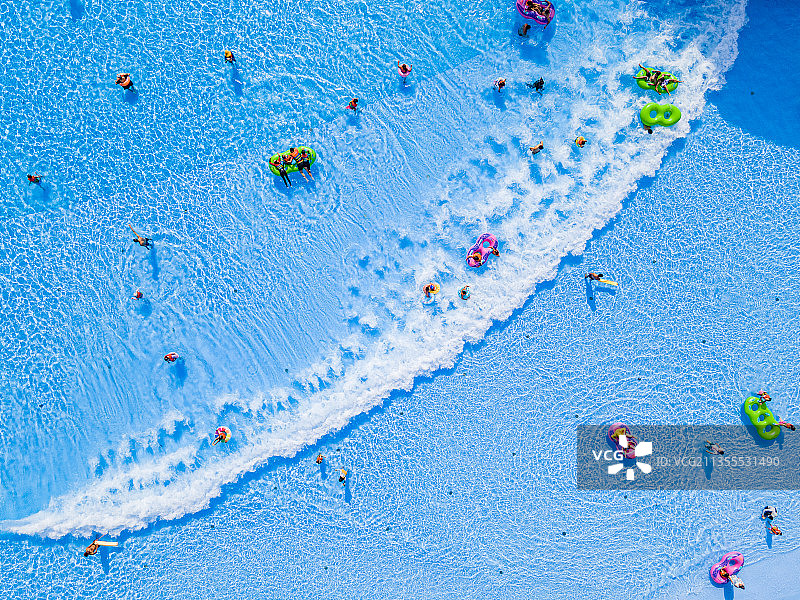 夏天水上乐园游泳池上的人群冲浪和游泳圈图片素材
